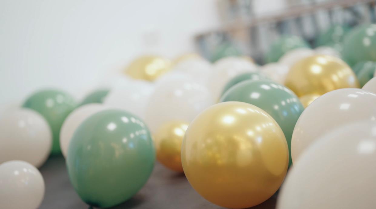 Festliche Dekoration mit mintgrünen, goldenen und weißen Ballons