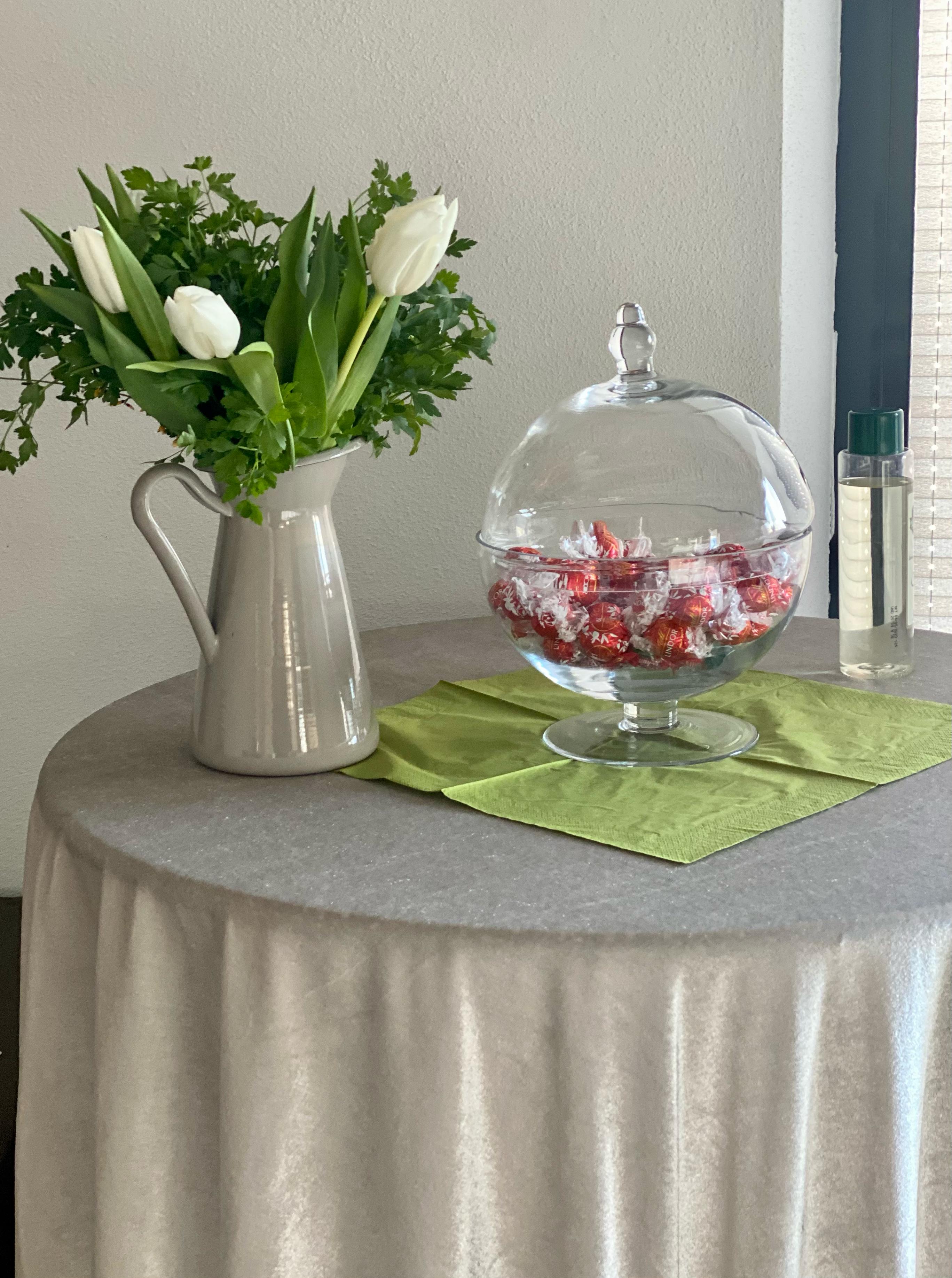 Gemütlicher Bereich mit rundem Tisch, weißen Tulpen und eleganter Tischdekoration